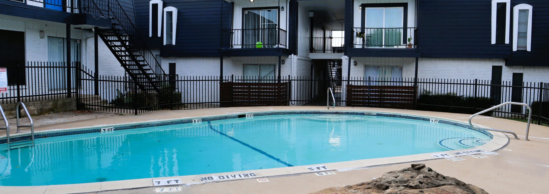 a swimming pool with a tennis court next to it