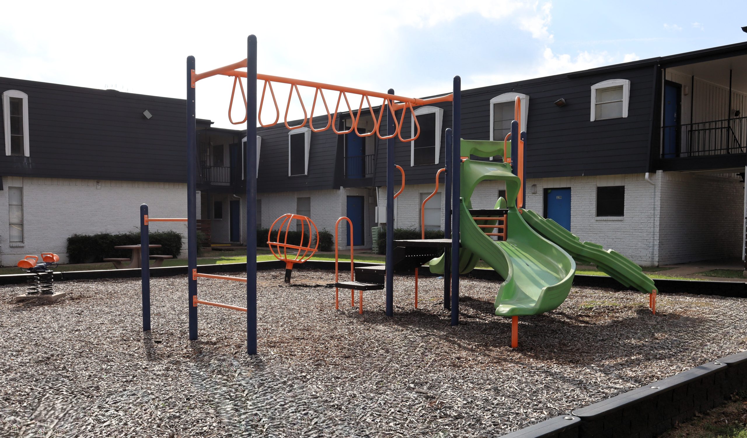 a green and yellow park bench in front of a building